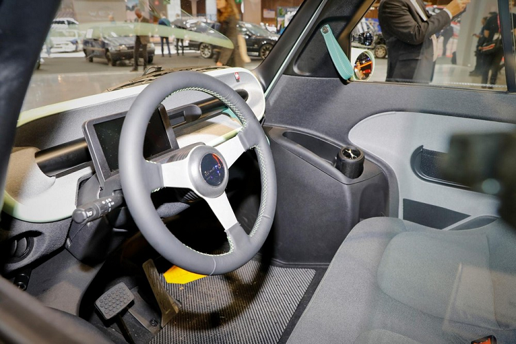 Phía sau mẫu xe điện Microlino Lite hình quả trứng này cũng có cụm đèn hậu nằm vắt ngang và đèn phanh trên cao. Tuy nhiên, đèn hậu của Microlino Lite nhỏ hơn so với Microlino 2.0 và nối với nhau bằng nẹp màu đen, tương tự đèn pha.