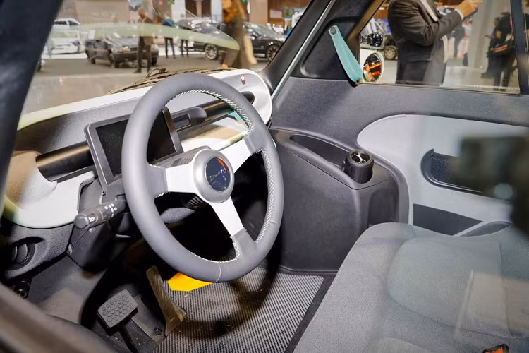 Phía sau mẫu xe điện Microlino Lite hình quả trứng này cũng có cụm đèn hậu nằm vắt ngang và đèn phanh trên cao. Tuy nhiên, đèn hậu của Microlino Lite nhỏ hơn so với Microlino 2.0 và nối với nhau bằng nẹp màu đen, tương tự đèn pha.