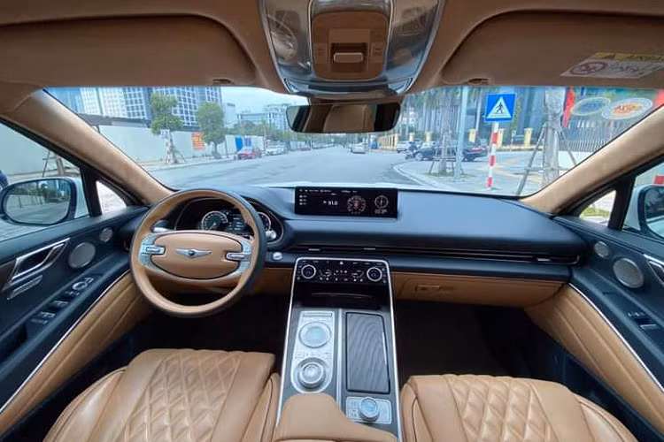 Genesis GV80 mang cấu hình 7 chỗ, tiêu chuẩn là 5 chỗ ngồi. Tương phản với màu trắng ngoại thất là màu nâu ở nội thất xe. Khoang lái nổi bật với vô lăng hai chấu (có sưởi), kiểu dáng hiếm thấy ở ô tô hiện đại cùng lẫy chuyển số và các vật liệu da và gỗ tông màu trầm cổ điển.