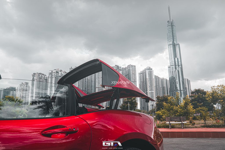 Chiếc xe thể thao mui trần được trang bị bộ mâm 8 chấu phủ màu bạc có kích thước 17 inch, bọc bên ngoài là bộ lốp Bridgestone cỡ 205/45. So với phiên bản mui mềm, Mazda MX-5 RF 2022 có điểm khác biệt duy nhất là thanh ngang đặt ở cột B. Kiểu thiết kế này khá giống mẫu Porsche 911 Targa. Xe được dán PPF toàn bộ ở GTA Wrapping để bảo vệ lớp sơn luôn sáng bóng.