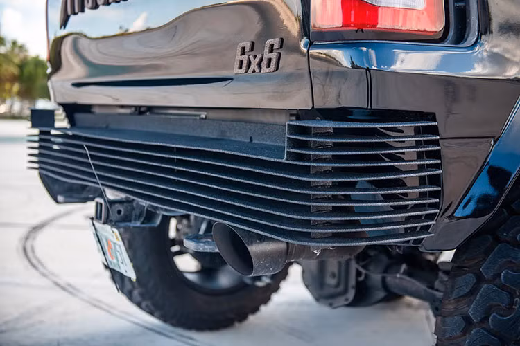 Bộ cản sau xe được làm từ những lá thép lớn, xếp song song như một hệ thống tản nhiệt khí. Vòm bánh lớn phía sau cũng được kéo phình rộng sang hai bên, tương tự như phía trước. Ngoài ra, bộ đèn phanh cũng như nắp thùng sau có vẻ như vẫn được giữ lại thiết kế nguyên bản, còn nóc thùng được độ đóng mở điện và trang bị khả năng chống chịu thời tiết.