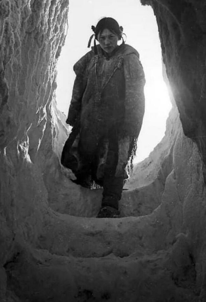 Một cô gái người Inuit đi xuống ngôi nhà băng tuyết của mình ở Arviat, Nunavut (miền Bắc Canada) vào năm 1949.