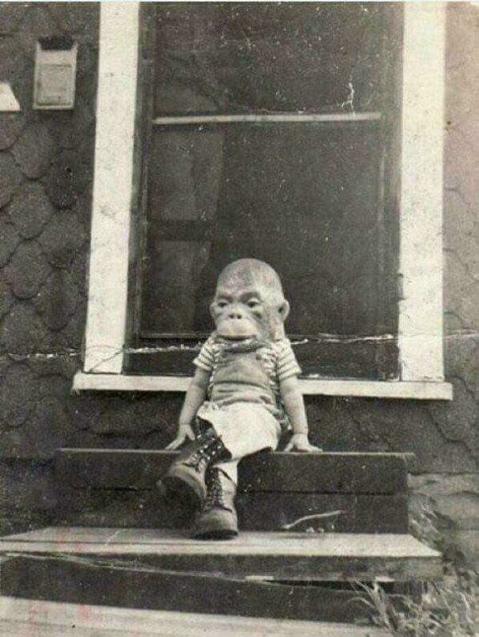 Bức ảnh hiếm chụp một đứa trẻ đeo mặt nạ khỉ ngồi trên bậc thềm những năm 1920.