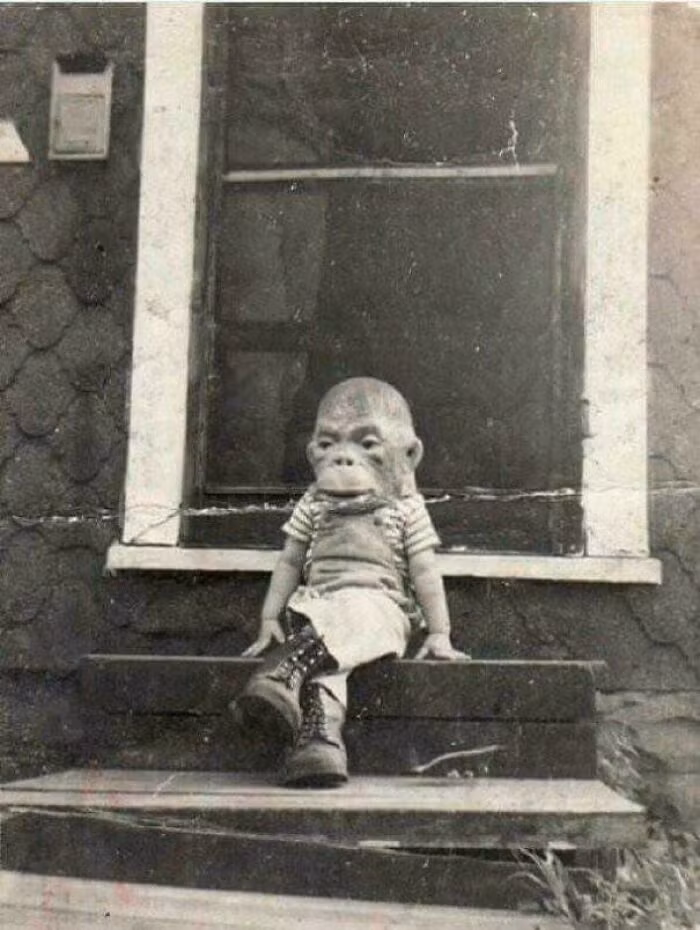 Bức ảnh hiếm chụp một đứa trẻ đeo mặt nạ khỉ ngồi trên bậc thềm những năm 1920.
