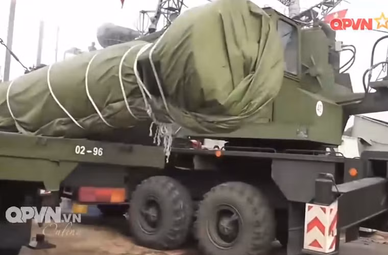 Quả ngư lôi khổng lồ nặng hàng tấn đang được hệ thống cẩu đưa khỏi xe vận tải để chuẩn bị công tác nạp vào bệ phóng. Nguồn ảnh: Kênh QPVN