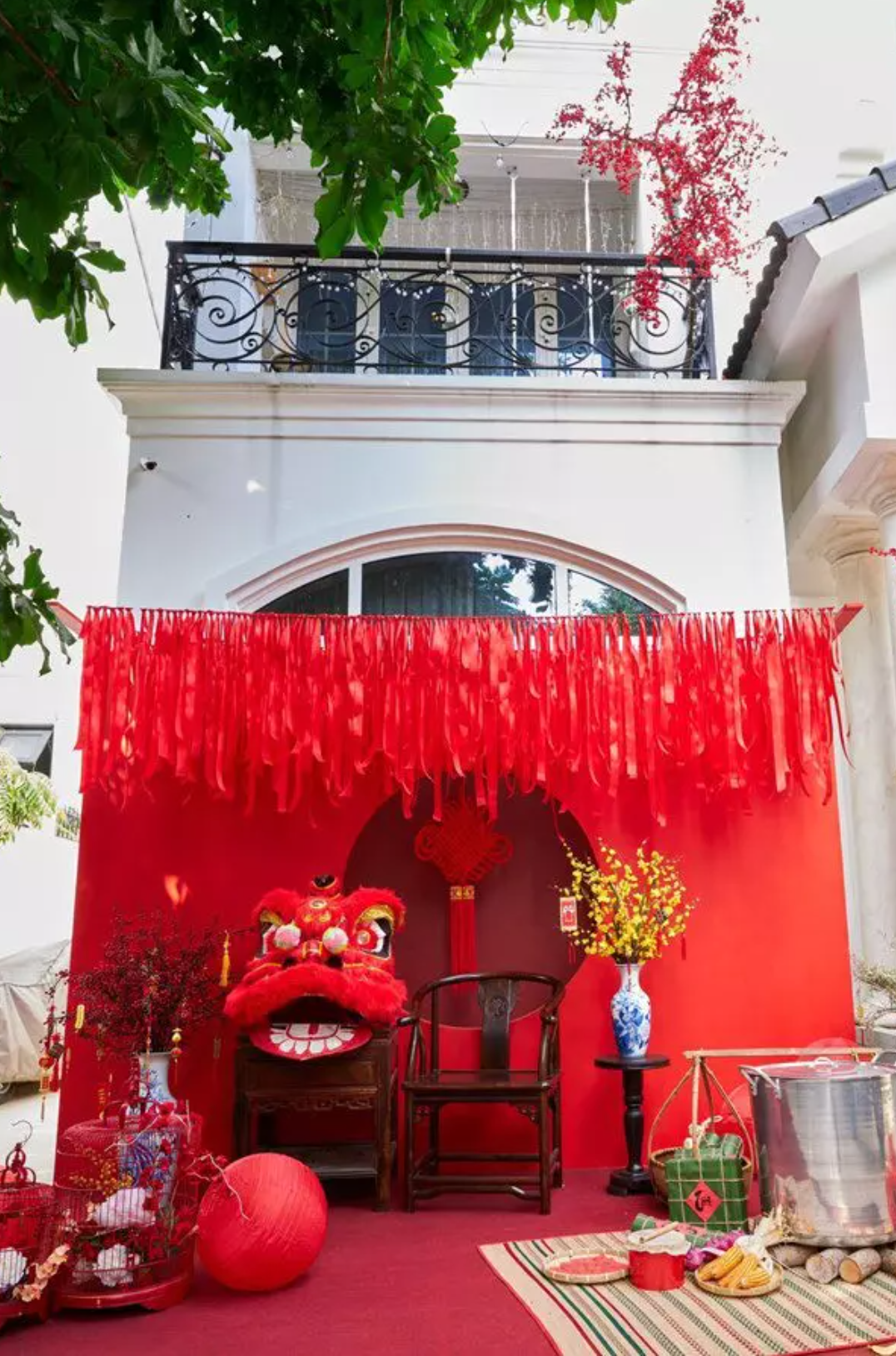 Tiếp đó là khu vực "check-in" phía trong với hoa quả, bánh chưng, giò lụa,... Phụ kiện đi kèm là đòn gánh và chiếc nồi luộc bánh. Nút thắt đồng tâm đặt phía trước ngôi nhà. Đây là đồ trang trí mang nhiều ý nghĩa may mắn, thuận buồm xuôi gió.