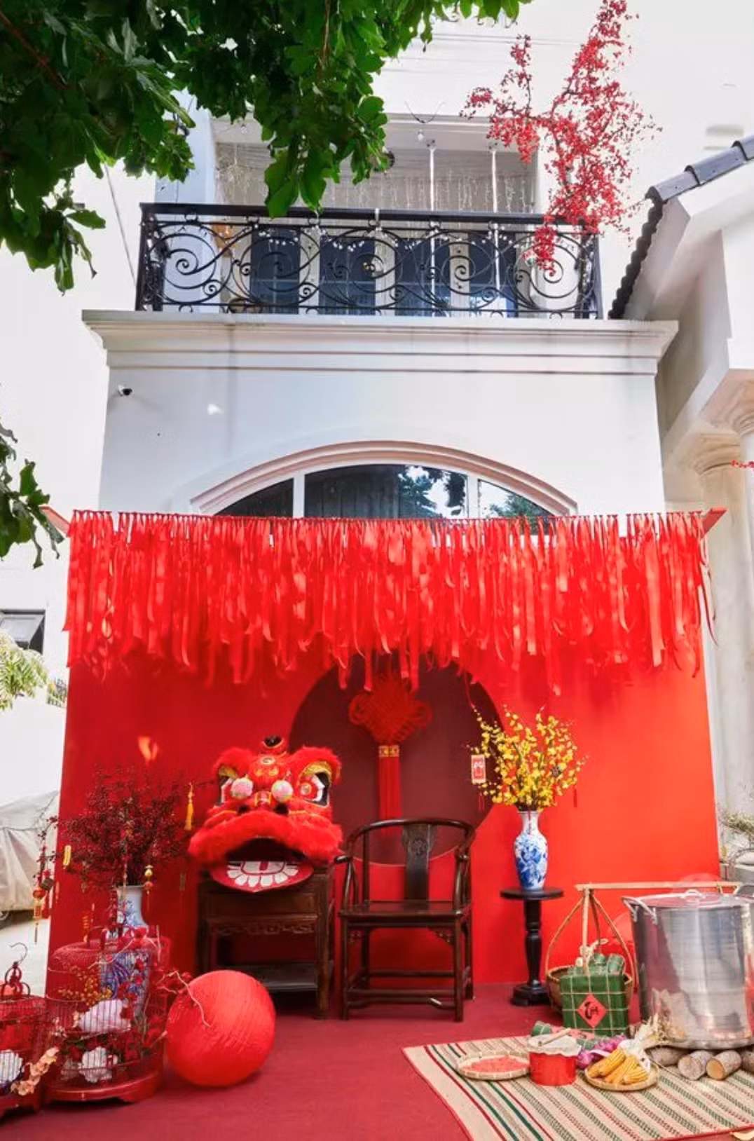 Tiếp đó là khu vực "check-in" phía trong với hoa quả, bánh chưng, giò lụa,... Phụ kiện đi kèm là đòn gánh và chiếc nồi luộc bánh. Nút thắt đồng tâm đặt phía trước ngôi nhà. Đây là đồ trang trí mang nhiều ý nghĩa may mắn, thuận buồm xuôi gió.