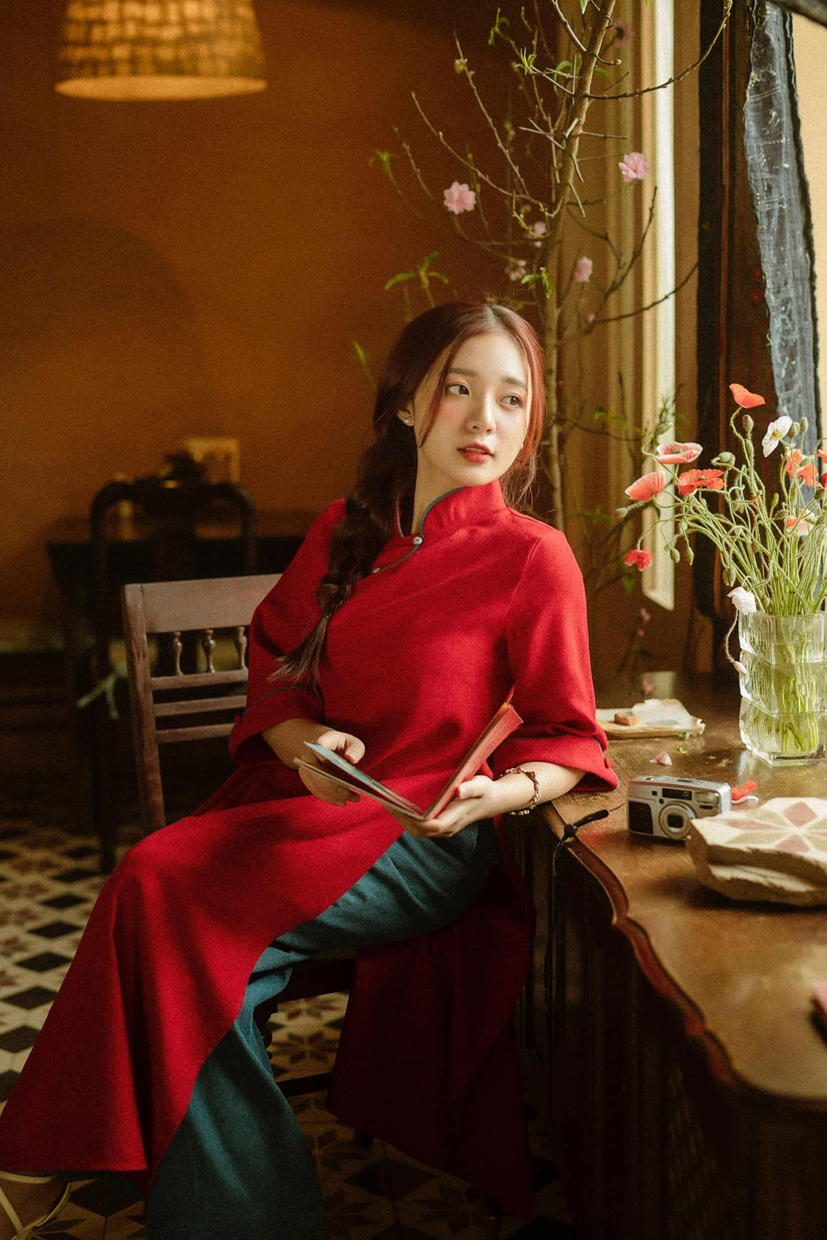 Diện áo dài đỏ, tết tóc một bên vai Vũ Phương Thảo khoe vẻ dịu dàng, đằm thắm chuẩn sắc màu ngày Tết.