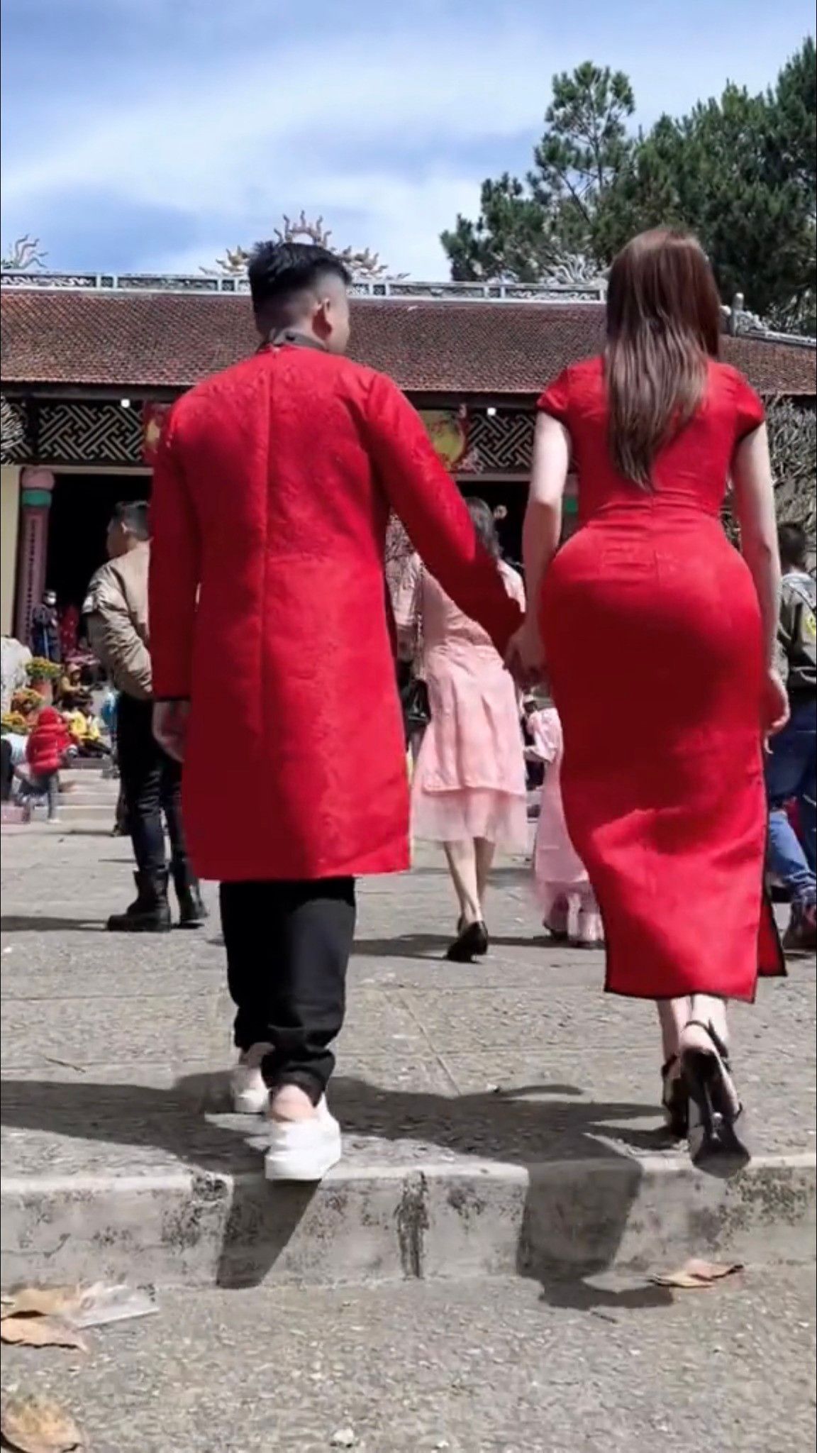 Theo đó, qua một đoạn clip ngắn trên Tik Tok, có thể thấy hot girl Trang Nemo và người bạn cùng trang phục đỏ khi đi lễ chùa. Tuy nhiên thay vì chọn áo dài kín đáo thì cô mặc áo dài giống sườn xám với phần chân váy xẻ tà và đeo giày cao gót mũi nhọn.