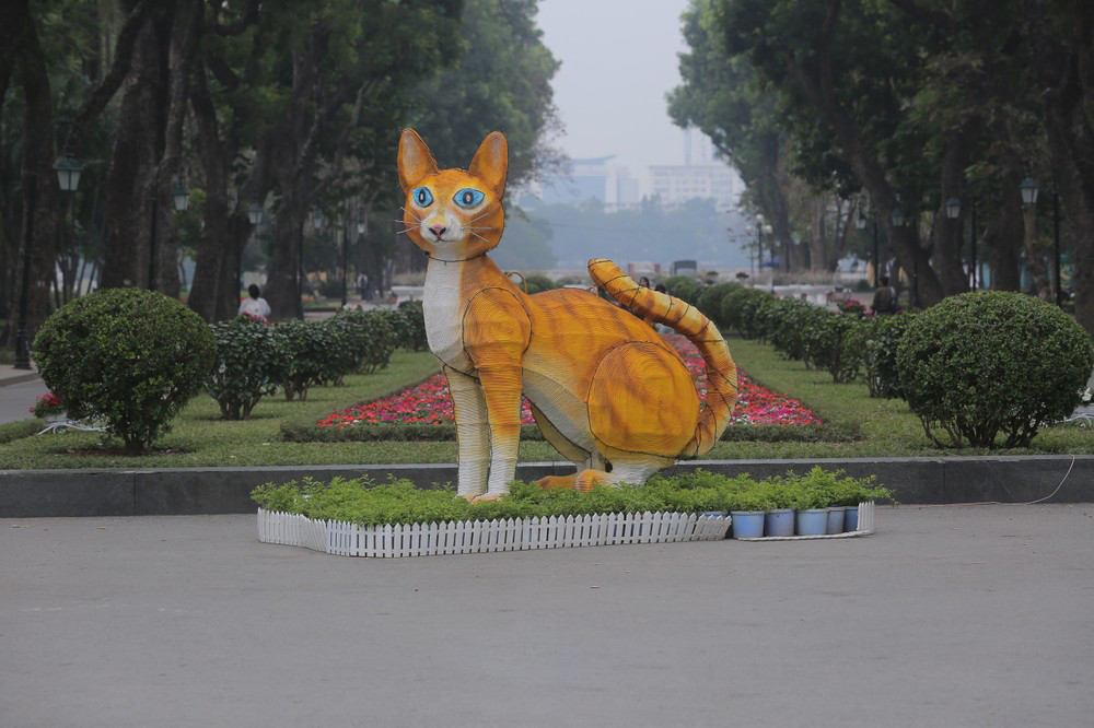 Theo hình ảnh ghi lại tượng linh vật mèo ở công viên Thống Nhất được dựng bằng khung sắt, chiều cao khoảng 2 m, dài gần 3 m, toàn thân được vẽ bằng màu vàng, trắng, mắt xanh. Ảnh: HÀ NỘI News