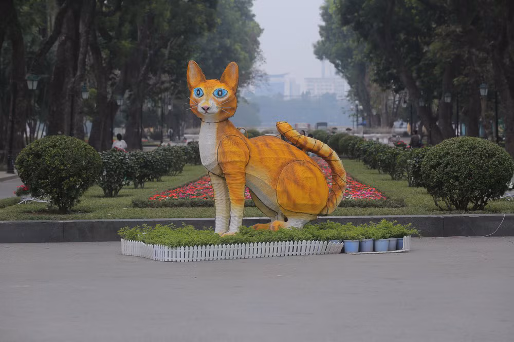 Theo hình ảnh ghi lại tượng linh vật mèo ở công viên Thống Nhất được dựng bằng khung sắt, chiều cao khoảng 2 m, dài gần 3 m, toàn thân được vẽ bằng màu vàng, trắng, mắt xanh. Ảnh: HÀ NỘI News