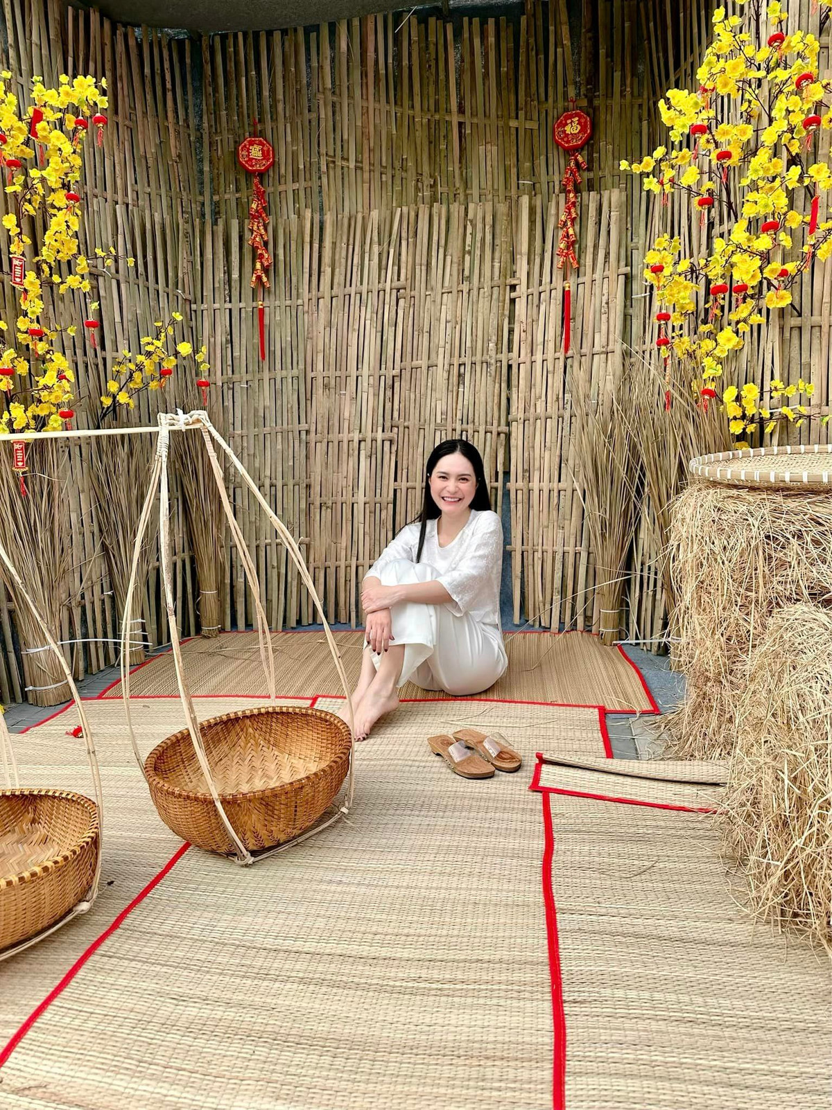 Đoàn Di Băng đã đầu tư cầu kỳ, tỉ mỉ hẳn một khu chợ Tết với nhiều chi tiết như rơm, gỗ mộc, tre, hoa cúc, chiếu cói,... để không gian chợ thêm phần giống ở đời thật.