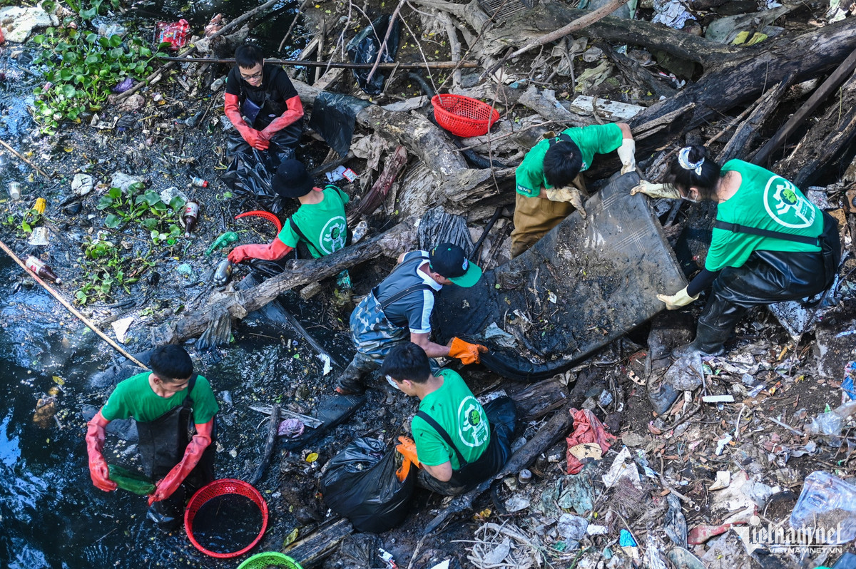 Các tình nguyện nữ đứng phía trên, chờ vận chuyển những bọc rác to và nặng.