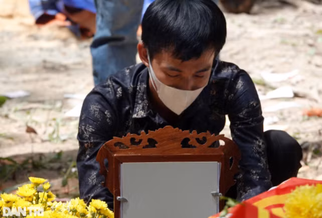 Anh Đạt - bố cháu bé thẫn thờ người nhìn di ảnh của con, bàn tay cứ nắm chặt vào nhau. Ánh mắt đỏ hoe, đượm buồn sau bao ngày mong mỏi tìm con. (Ảnh: Dân Trí)