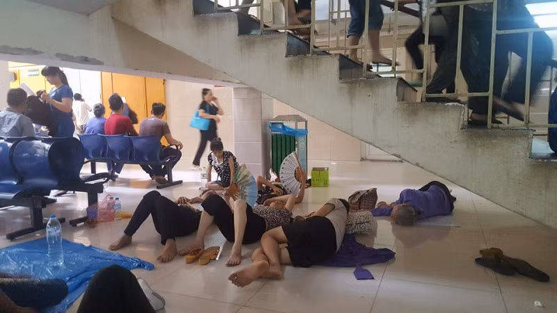 Người nhà bệnh nhân trốn trong gầm cầu thang Bệnh viện Bạch Mai để tránh nóng.