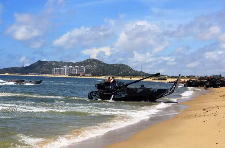 Xe tăng lội nước ZTD-05 trang bị pháo chính 105mm tiến vào bờ trước che chắn đạn cho đội hình xuồng máy chở quân đổ bộ lao nhanh phía sau.