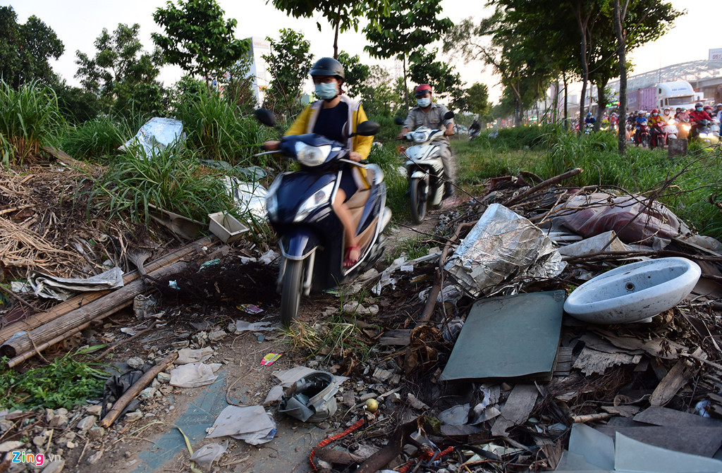 Những đống rác, xà bần bên Xa lộ Hà Nội thuộc phường Phước Long A, quận 9 hướng về ngã tư Thủ Đức bị chia làm đôi, tạo thành lối mòn cho nhiều người chạy xe máy tìm đường thoát về nhà khi đi qua ngã tư này.