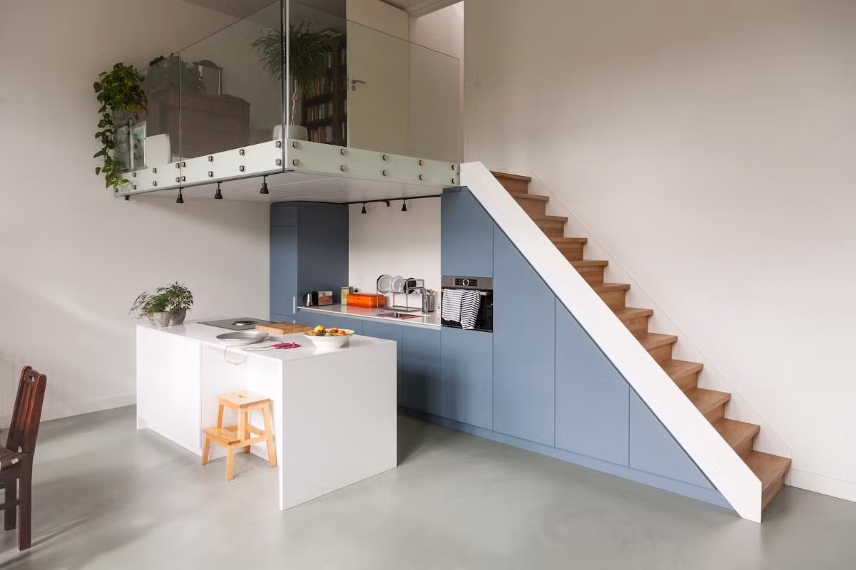 Bếp và bàn ăn được thiết kế khéo léo dưới gầm gác lửng giúp căn hộ trở nên gọn gàng và tiện nghi.