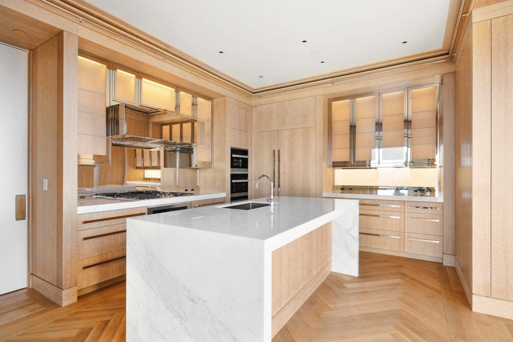 Nhà bếp sang trọng với tủ gỗ, đảo bếp bằng đá cẩm thạch trắng.