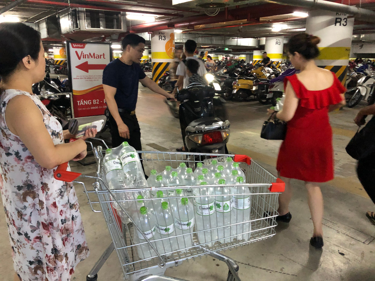 Một gia đình chuyển nước khoáng về nhà bằng xe máy.