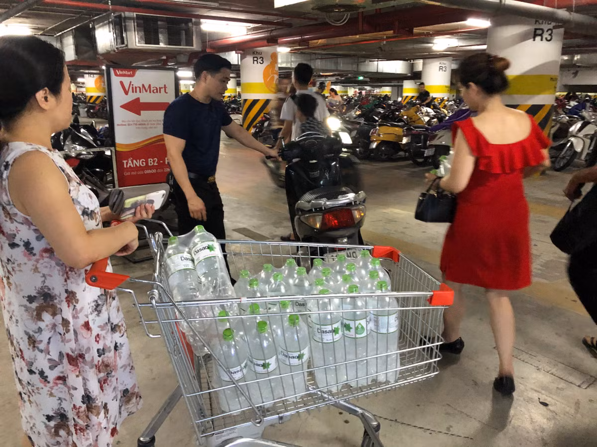 Một gia đình chuyển nước khoáng về nhà bằng xe máy.