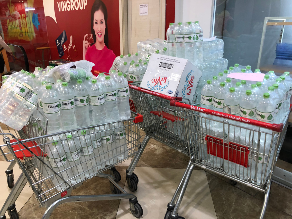 Tại một siêu thị Vinmart ở Hà Nội, hàng loạt xe đẩy chất đầy những thùng nước khoáng đóng chai được xếp sẵn chờ chuyển đến tay khách hàng.