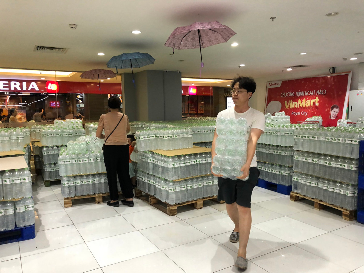 Một người đàn ông chủ động mua nước khoáng tại siêu thị.