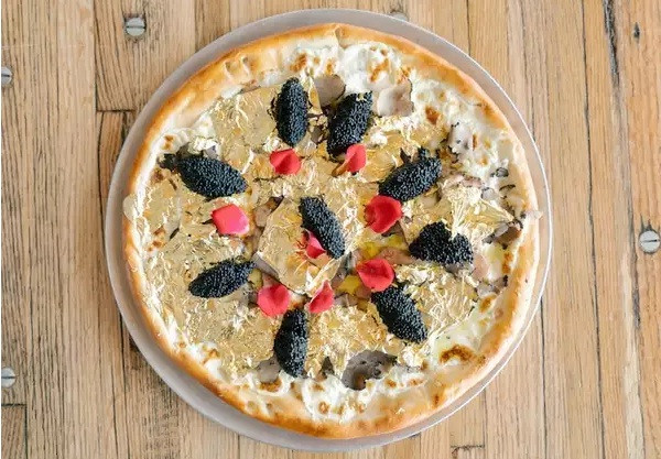 Chiếc bánh pizza 24 karat của Industry Kitchen, New York... chứa vàng thật. Giá một miếng là 250 USD (5,7 triệu), giá nguyên bánh là 2.000 USD (45,6 triệu đồng).