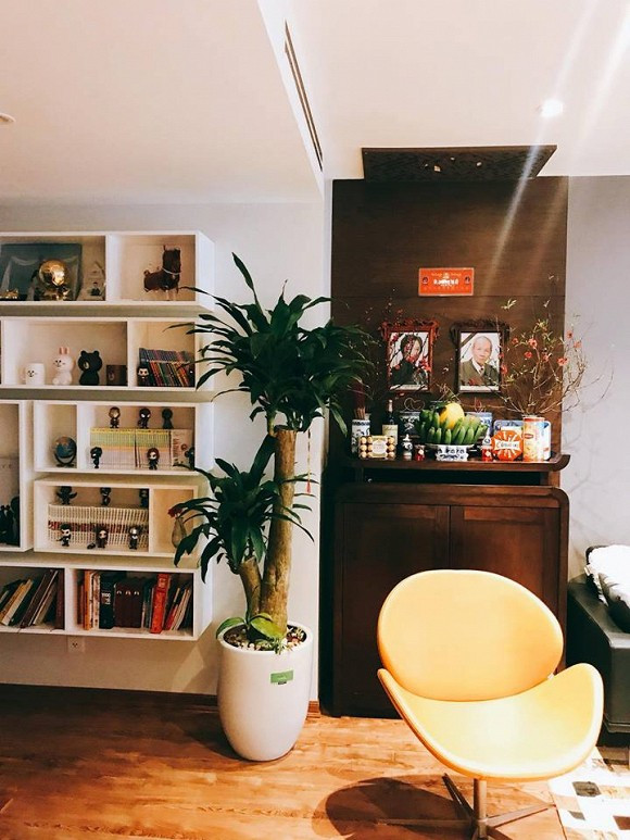 Ban thờ trang trọng được bố trí ngay trong phòng khách. Bên cạnh là một chiếc tủ chứa sách và các đồ vật lưu niệm.