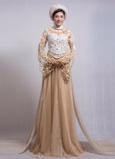 Chiếc áo dài có gam màu trắng ngọc trai chủ đạo, kết hợp với phần áo rời khoác ngoài được kết từ kim cương nhân tạo, ngọc trai và đá swarovski, các ren trên thân áo được sắp xếp tinh xảo từ tạo hình của những cành san hô dưới biển. Ảnh: ChaPi, Tay Kaka