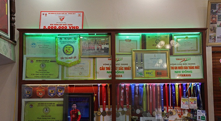 Trên tường phòng khách có tủ kệ gỗ, trưng bày các huy chương, giải thưởng của Quang Hải. Ảnh: Vietnamnet.