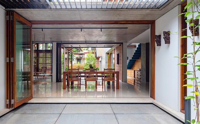 Một chiếc cửa bằng kính có thể gấp lại, mở ra không gian rộng cho căn nhà.