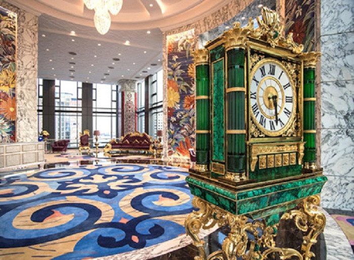 Chiếc đồng hồ khổng lồ khảm đá mosaic theo phong cách cổ điển trên nền đá chạm trổ bằng đồng mạ vàng 24K nổi bật tại sảnh. Ảnh: Booking