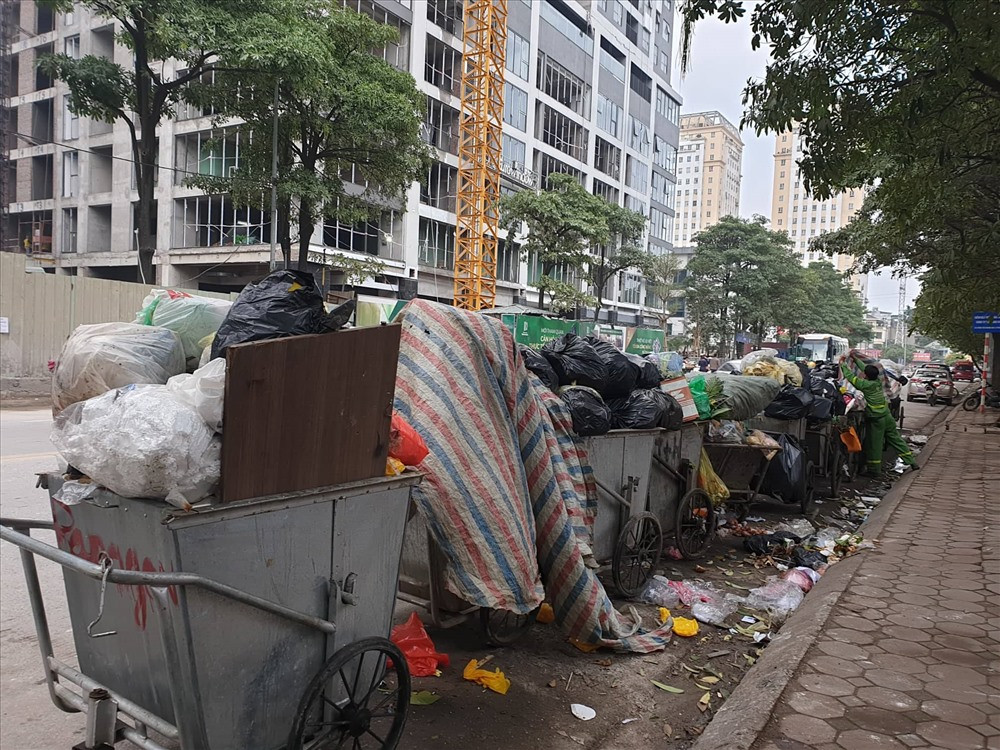 Trong đó, quận Cầu Giấy (320 tấn/ngày đêm) là một trong những điểm có rác được phân luồng về ô chôn lấp tại Khu xử lý chất thải rắn Xuân Sơn. Theo ghi nhận của Lao Động, dọc trên tuyến phố Duy Tân và Thành Thái (Cầu Giấy) có nhiều điểm tập kết rác khác nhau. Do lượng rác trong ngày bị tồn quá lớn dẫn đến các điểm lưu chứa tại các điểm chung chuyển, tập kết tạm thời là rất lớn, mỗi điểm có đến gần 20 xe chứa đầy rác.