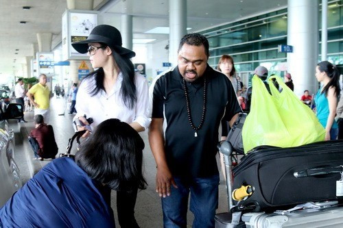 Hai vợ chồng tranh thủ mang hành lý lên xe.