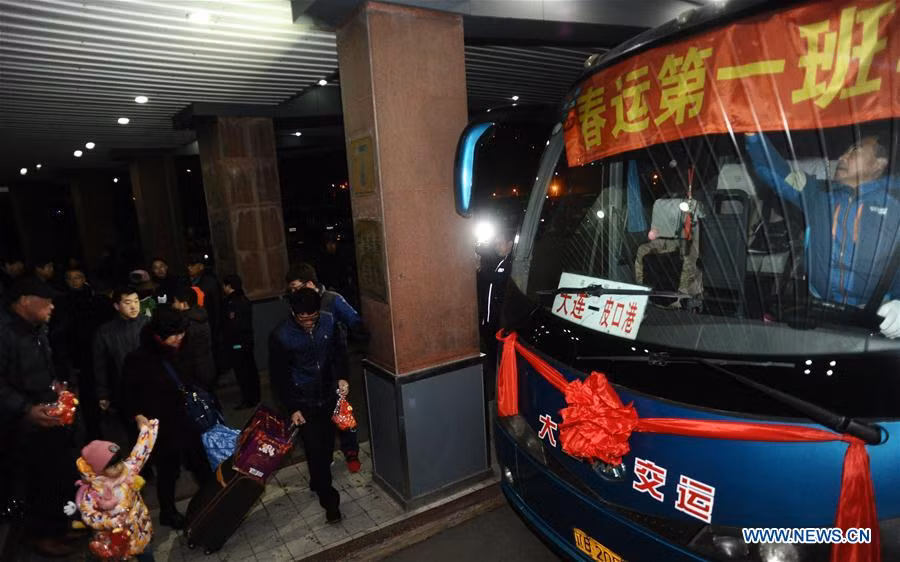 Hành khách xếp hàng lên xe buýt tại bến xe buýt Beigangqiao ở Đại Liên, tỉnh Liêu Ninh, ngày 13/1.