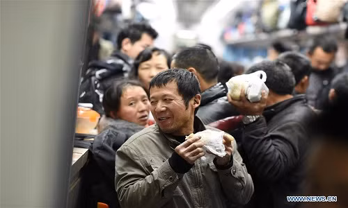 Được biết, chuyến tàu này khởi hành từ nhà ga Phúc Châu ở tỉnh Phúc Kiến, chạy qua nhiều khu vực và tới Quảng An, tỉnh Tứ Xuyên. Ảnh: Những người công nhân nhập cư tranh thủ ăn trong lúc ngồi trên tàu về quê ăn Tết ở Trung Quốc.