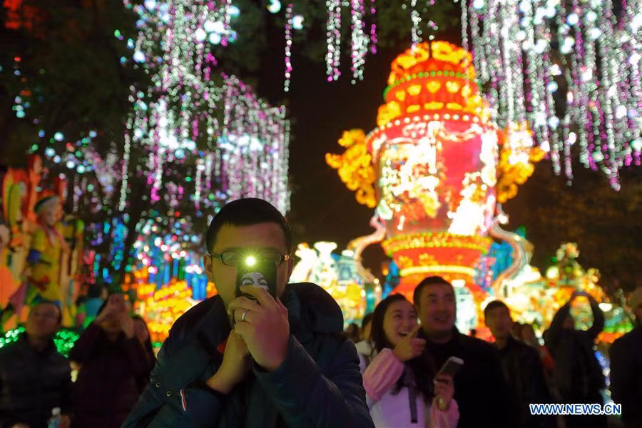 Một du khách dùng điện thoại chụp ảnh trong lễ hội đèn lồng rực rỡ ở thành phố Tự Cống.