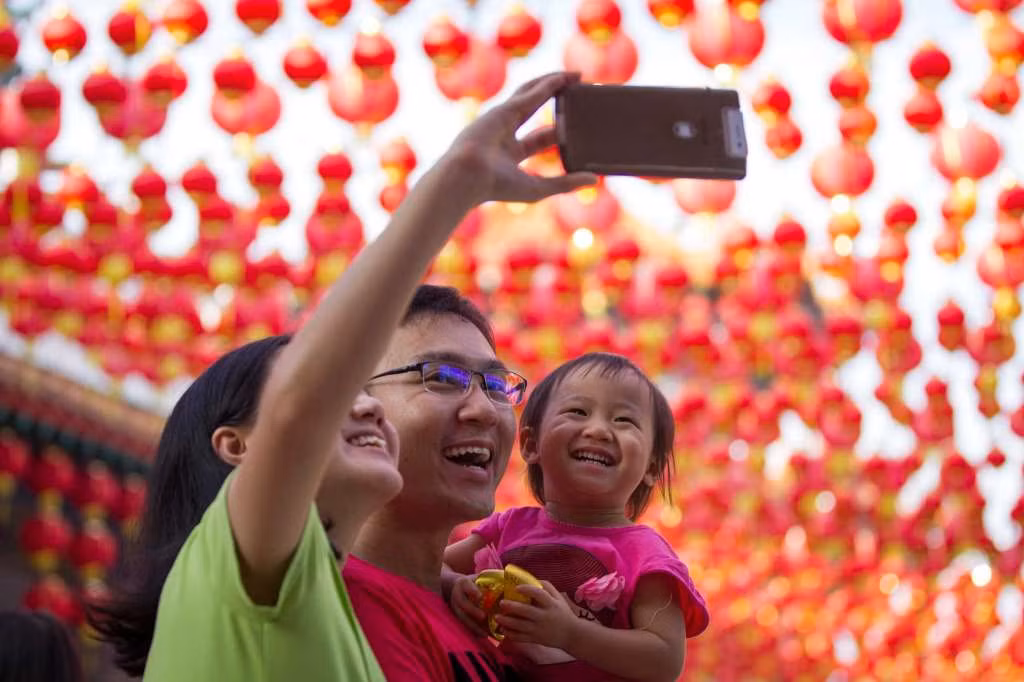 Một gia đình chụp ảnh lưu niệm tại ngôi chùa ở thủ đô Kuala Lumpur, Malaysia, trong ngày đầu tiên của năm mới Âm lịch 2017.