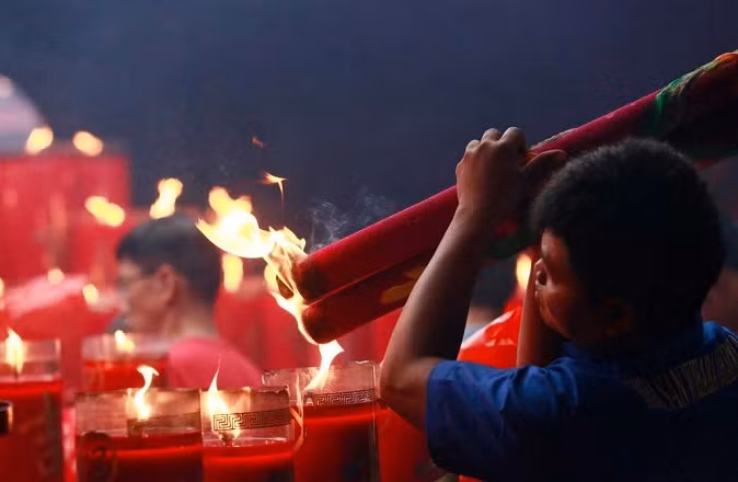 Người đàn ông gốc Hoa đang thắp những nén hương khổng lồ tại chùa Dharma Bakti hôm 28/1.