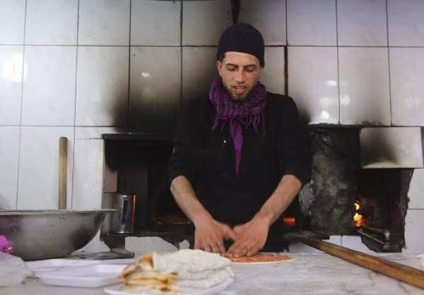 Một người đàn ông Iraq đang nấu ăn trong cửa hàng.