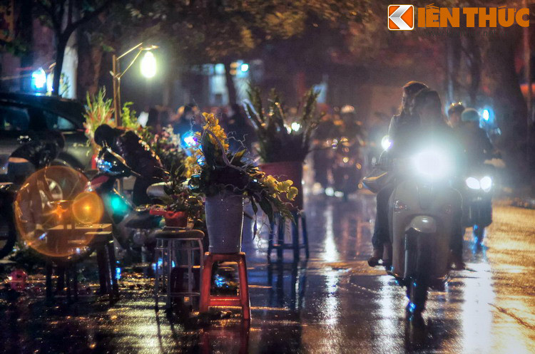 Trên phố Hàng Lược, các hàng hoa vẫn mở bán cho đến trước Giao thừa. Mặt đường ướt đẫm do mưa phùn, tiết trời đặc trưng của Hà Nội vào dịp Tết.