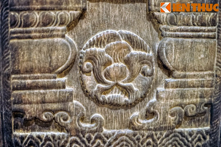 Ô dưới mỗi cánh cửa chạm hai bông hoa cúc nở đối xứng, phía trên chạm lá đề, cánh sen kép, hàng dưới chạm sóng nước.