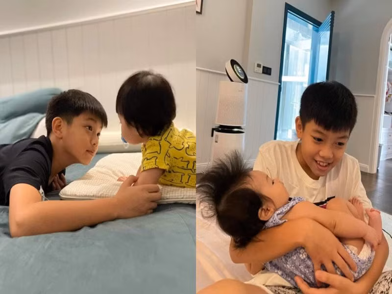 Cậu nhóc bế em gái Suchin lúc nhỏ. Ảnh: Người Đưa Tin.