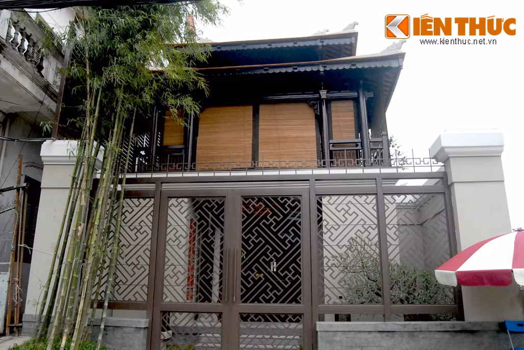 Chiếc cổng hai tầng, mái ngói uốn cong như lối vào cung đình xưa, hàng rào hoa văn nhẹ nhàng và đẹp mắt.