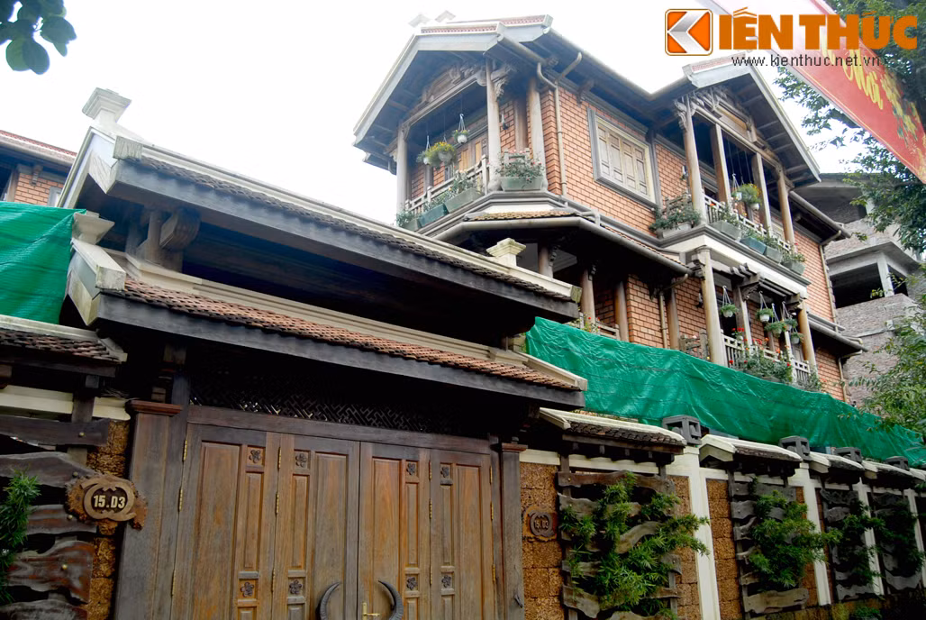 Trong hình là căn biệt thự gỗ, mang đậm nét kiến trúc Á đông, tường bao quanh làm từ đá ong đẹp mắt.