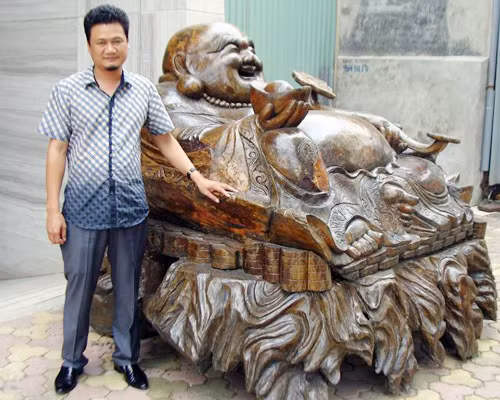 Pho tượng Phật Di Lặc bằng gỗ cao 1,5 mét, rộng 2,4 mét, nặng tới năm tấn của đại gia Hà Thành Trần Đức Thuấn được coi là một trong những pho tượng gỗ "khủng" ở Việt Nam.