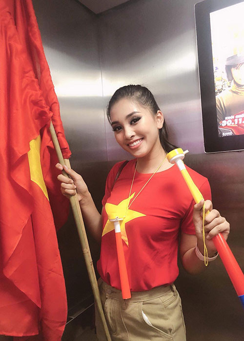 Hoa hậu Tiểu Vy mặc áo cờ đỏ sao vàng xuống đường ăn mừng.