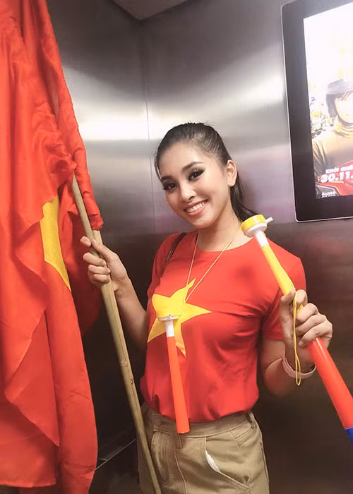 Hoa hậu Tiểu Vy mặc áo cờ đỏ sao vàng xuống đường ăn mừng.