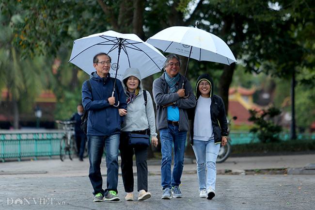 Nhóm khách du lịch người Singapore co ro trong gió lạnh trên phố đi bộ Hà Nội.